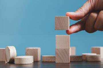Stacking blank wooden cubes on blue background with copy space for input wording and infographic icon. Empty brown wooden object block for symbol icon put technology, zero gravity, business concept.