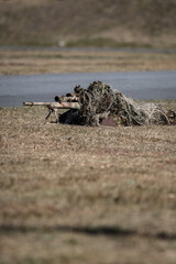 ギリースーツを着た狙撃手（sniper in ghillie suit with presicion rifle）