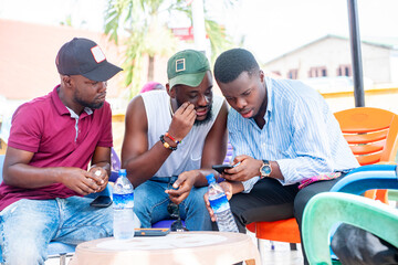 selective focus of african guys with smart phone outside-  black guys enjoying social media surf