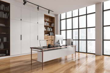 Light office interior with work desk and cabinet near panoramic window - obrazy, fototapety, plakaty