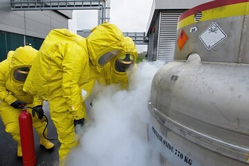Firefighters in protective chemical hazmat suits stop a simulated leak of the dangerous chemical...