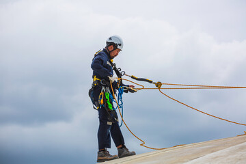 Male workers clear rope access wearing safety first harness rope safety line