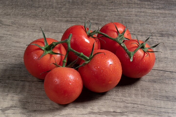 tomatoes on a wooden table with water droplets