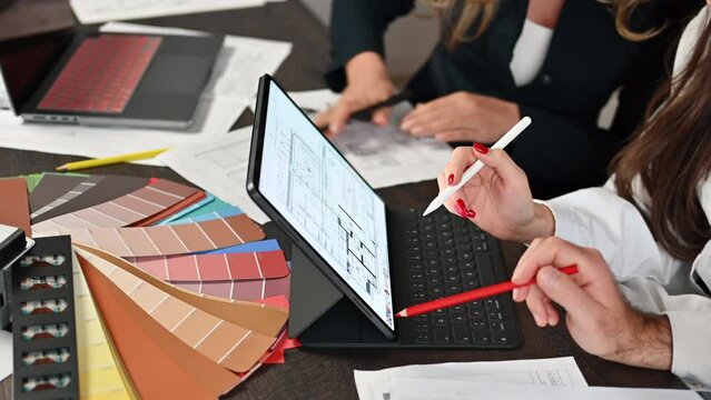 Business designers working with chars and colored blueprints at the office