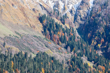 Beautiful autumn landscape in the mountains. Golden autumn. Colorful forest on the slopes of steep mountains.