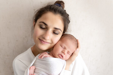 portrait of a mother with a sleeping newborn baby, the concept of a happy family and motherhood