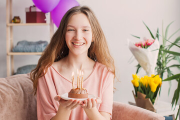 young woman looking at birthday cake with candle