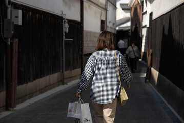 土産袋を提げて歩く観光客の女性