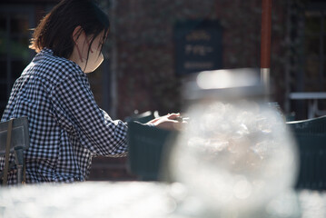 屋外でテーブルに座る女性 前ボケ