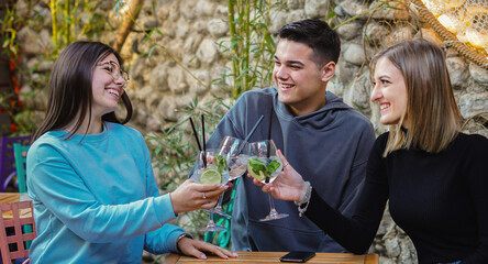Young people have fun in a bar - Friends drinking cocktails together.