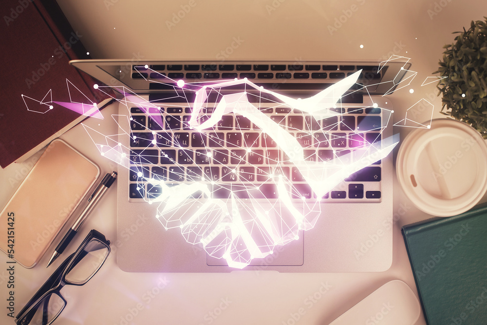 Poster handshake drawing over computer on the desktop background. top view. double exposure. partnership co