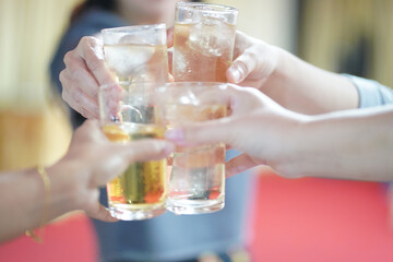 Hands clinking drinking glasses with friends at a fun and happy party.,select focus