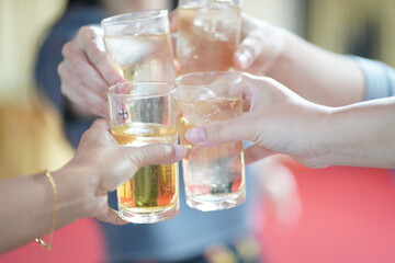 Hands clinking drinking glasses with friends at a fun and happy party.,select focus