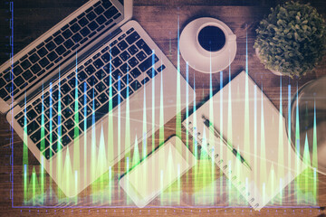Financial market graph and top view computer on the desktop background. Double exposure. Investment concept.