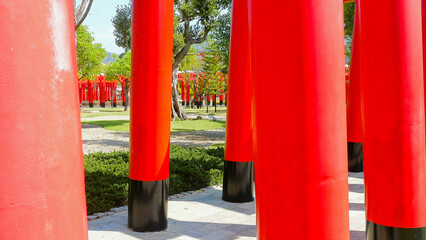 Close up of red torii gates in park. Walking inside Japanese shrine