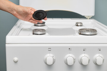 man washing a gas stove with a rag.