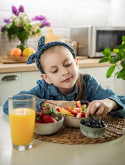 Cute little girl eats fruit salad