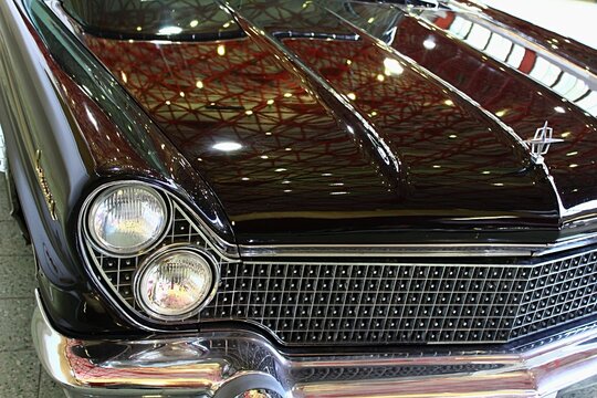 Front mask, massive grille and typical twin round headlights of Lincon Continental Mark V, luxury limousine from 1960, brown metallic colour, as displayed on car expo in Nitra, Slovakia.