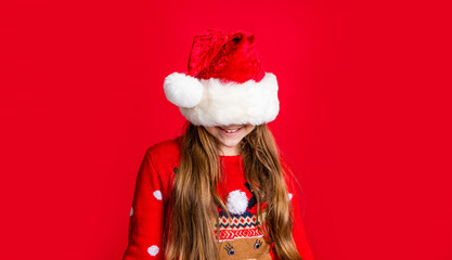 Fototapeta na wymiar merry christmas. funny teen girl in santa claus hat on red christmas background. christmas teen girl