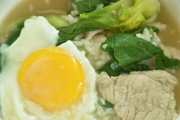 boiled rice with slice fermenting  pork and cabbage topping egg yolk on bowl 