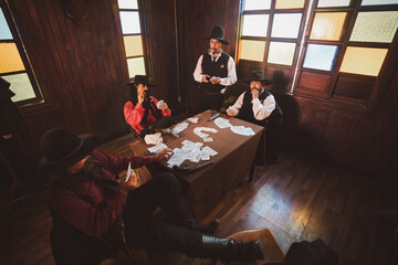 Cowboys group playing poker and card  gambler game in old American west saloon is cowboy vintage...