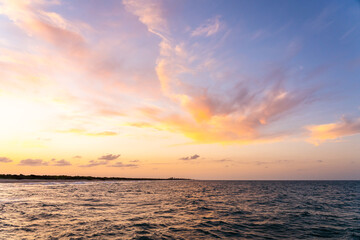 Fototapeta na wymiar Golden colors of a sunset over the Atlantic Ocean in Florida. View from the jetty