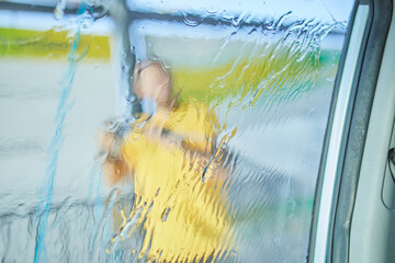 Man washing his car, using on self service washing, contactless high pressure water jet..