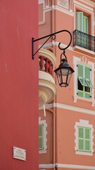 Colorful buildings with window frames, a balcony and a streetlight
