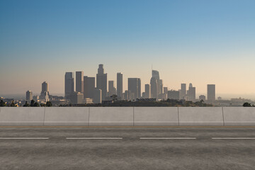 Empty urban asphalt road exterior with city buildings background. New modern highway concrete construction. Concept of way to success. Transportation logistic industry fast delivery. Los Angeles. USA.