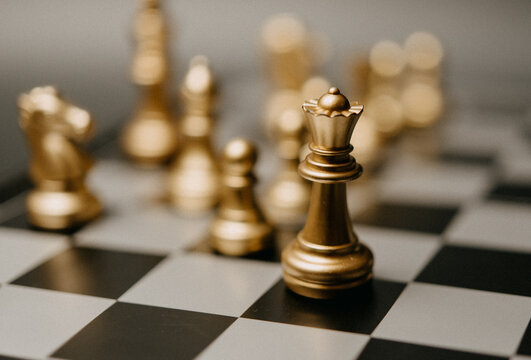 Golden King chess standing in front on board game. Concept leadership strategy business.