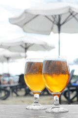 Cold beer in glass on beach. Space for text
