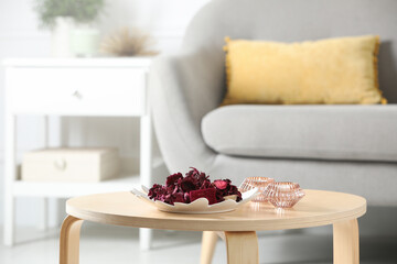 Aromatic potpourri of dried flowers and candles on coffee table indoors