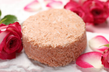 Solid shampoo bar and roses on table, closeup. Hair care