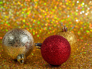 Christmas balls on a golden background. Christmas decoration with beautiful bokeh.