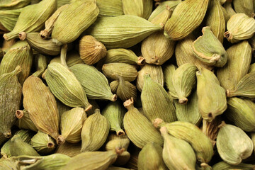 Pile of dry green cardamom pods as background, closeup