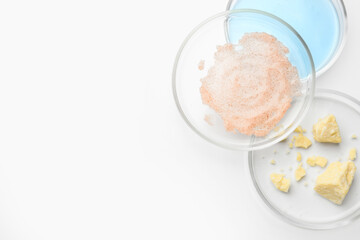 Many Petri dishes and cosmetic products on white background, top view