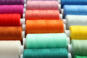 Set of different colorful sewing threads as background, closeup