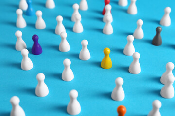 Colorful pawns on light blue background. Social inclusion concept