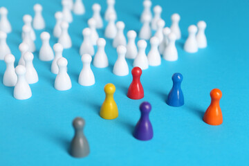 Colorful pawns on light blue background. Social inclusion concept