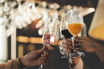 Close up hand clink a glass of champagne and wine to celebrate at a party in the bar restaurant