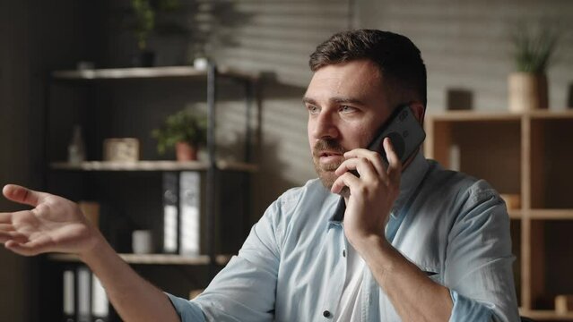 Stressed young man hearing awful news at mobile phone call conversation.