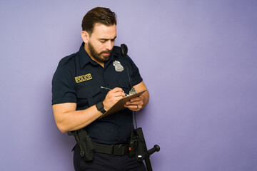 Police agent using giving a traffic fine against a studio background