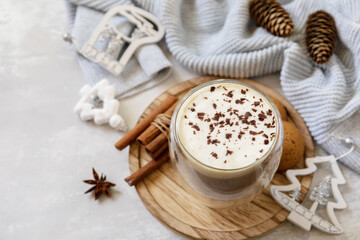 Seasonal winter concept with hot drink. Latte spice coffee, warm pullover and Christmas decor on gray background