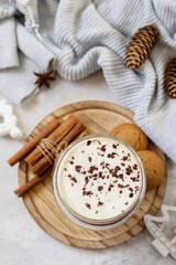 Latte spice coffee, warm pullover and Christmas decor on gray background.  Seasonal winter concept with hot drink.