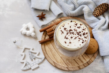 Fototapeta na wymiar Latte spice coffee, warm pullover and Christmas decor on gray background. Seasonal winter concept with hot drink. Copy space.