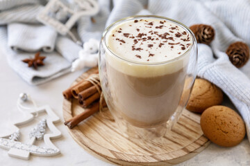 Latte spice coffee, warm pullover and Christmas decor on gray background.  Seasonal winter concept with hot drink.
