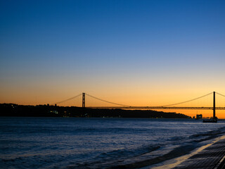 sunset on the Tagus river with the 25th of April bridge in the background