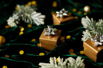 Fototapeta na wymiar Gold gift boxes with silver ribbon on shine velur green background, with christmas decorations, Flat lay. Copy space. Marry Christmas