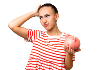 Young Arab woman holding a piggybank over isolated background having doubts and with confuse face expression