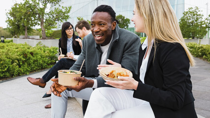 Happy multiracial business people having a lunch break outside office - 542171692